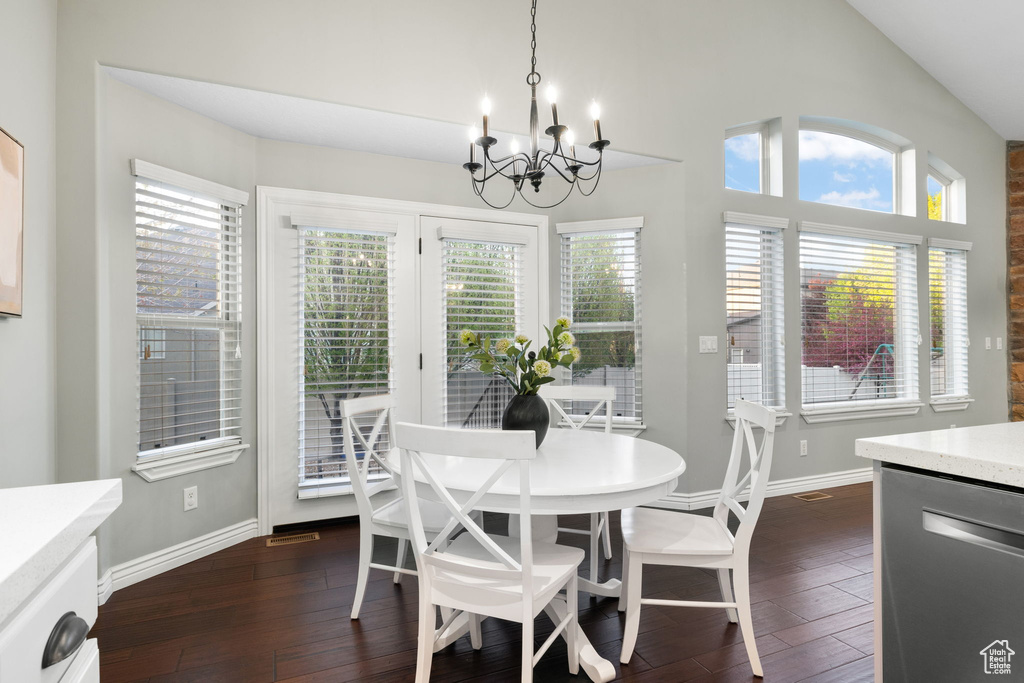Dining room with a chandelier, baseboards, and dark wood-style flooring