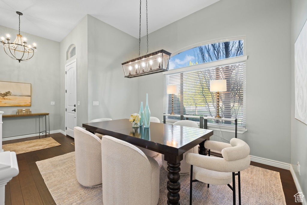 Dining room with a chandelier, dark wood finished floors, and baseboards