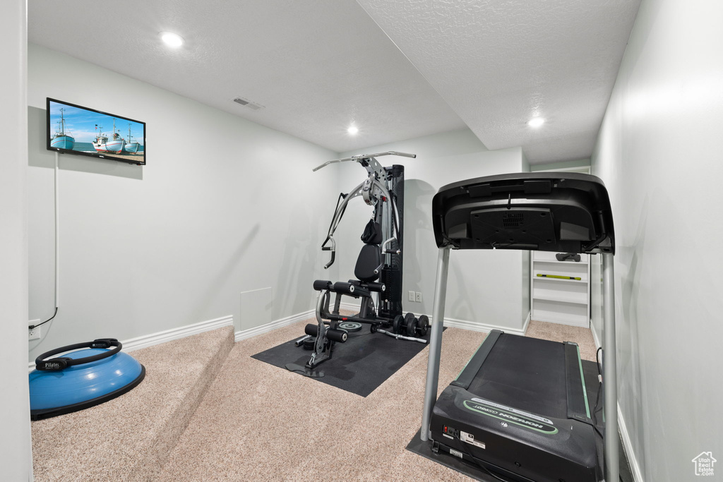 Exercise area with recessed lighting, visible vents, and baseboards