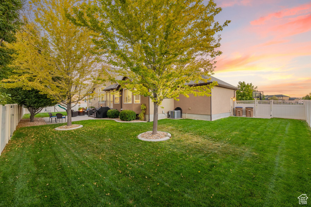 View of yard featuring a fenced backyard, cooling unit, and a patio