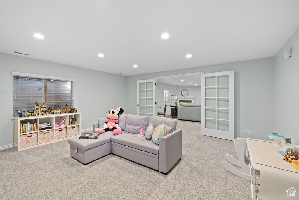 Carpeted living room featuring baseboards, french doors, visible vents, and recessed lighting