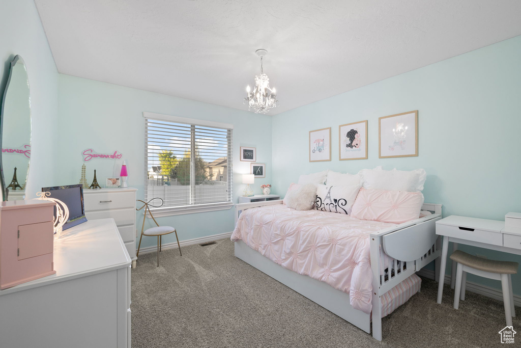Bedroom with carpet floors, visible vents, baseboards, and a notable chandelier