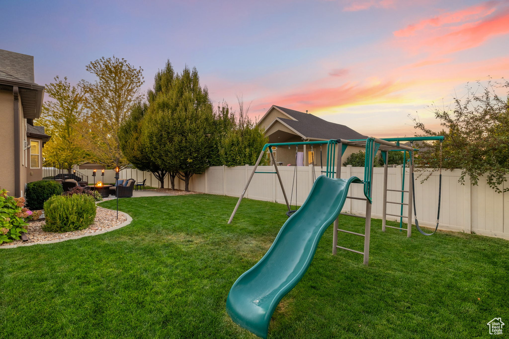 View of jungle gym with a lawn and a fenced backyard