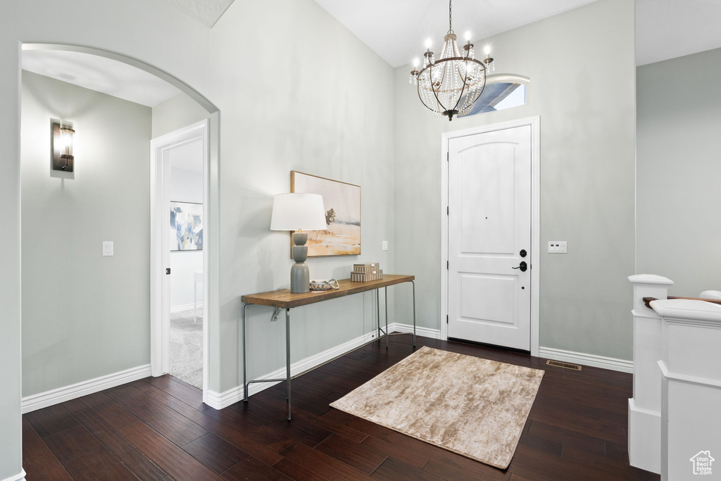 Entrance foyer featuring arched walkways, hardwood / wood-style floors, and baseboards