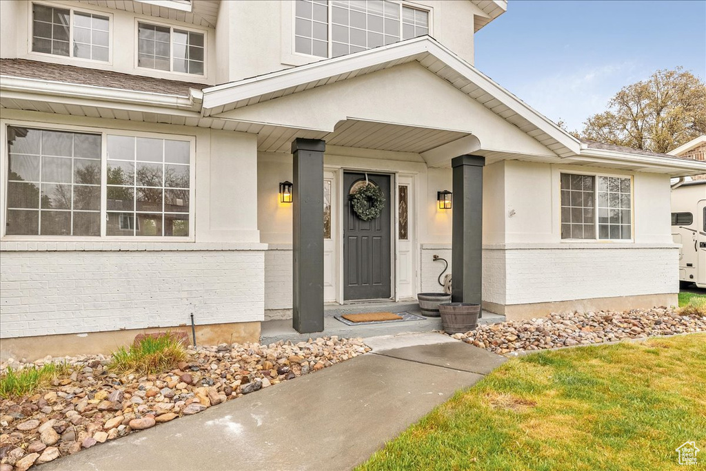 View of exterior entry featuring stucco siding and brick siding