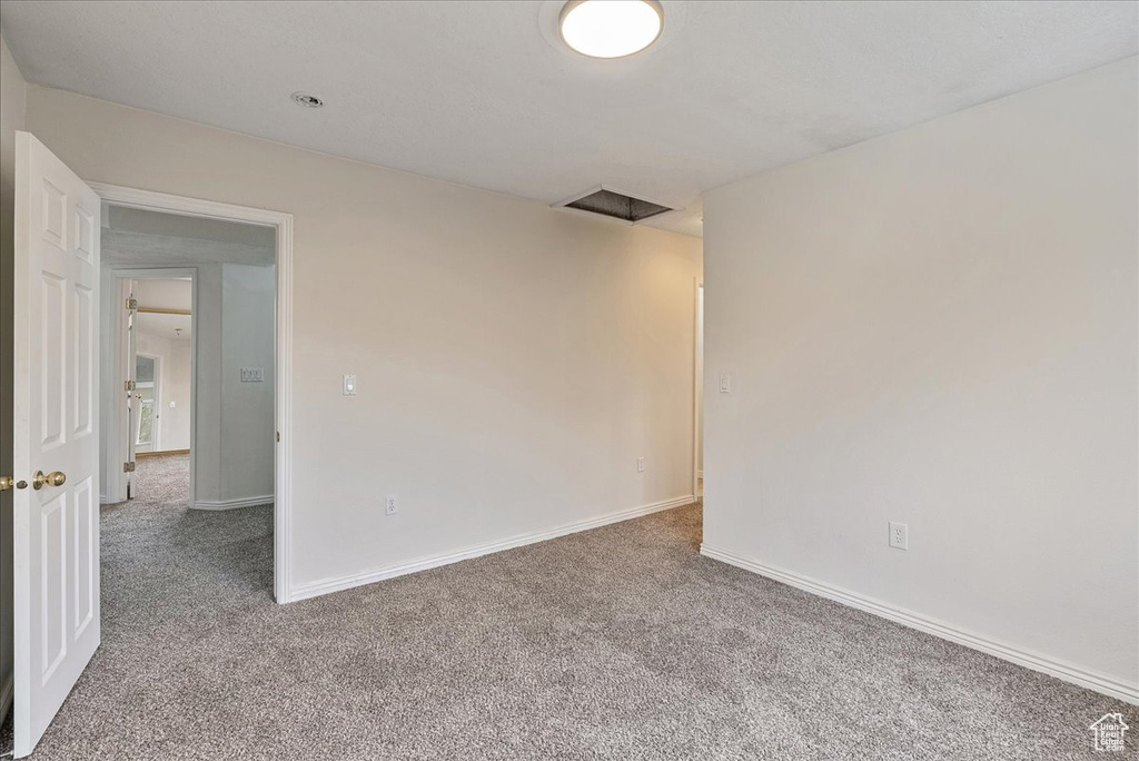 Spare room featuring carpet floors and baseboards