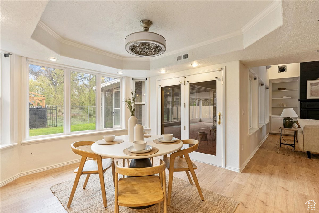 Sunroom / solarium with baseboards, wood finished floors, and a raised ceiling