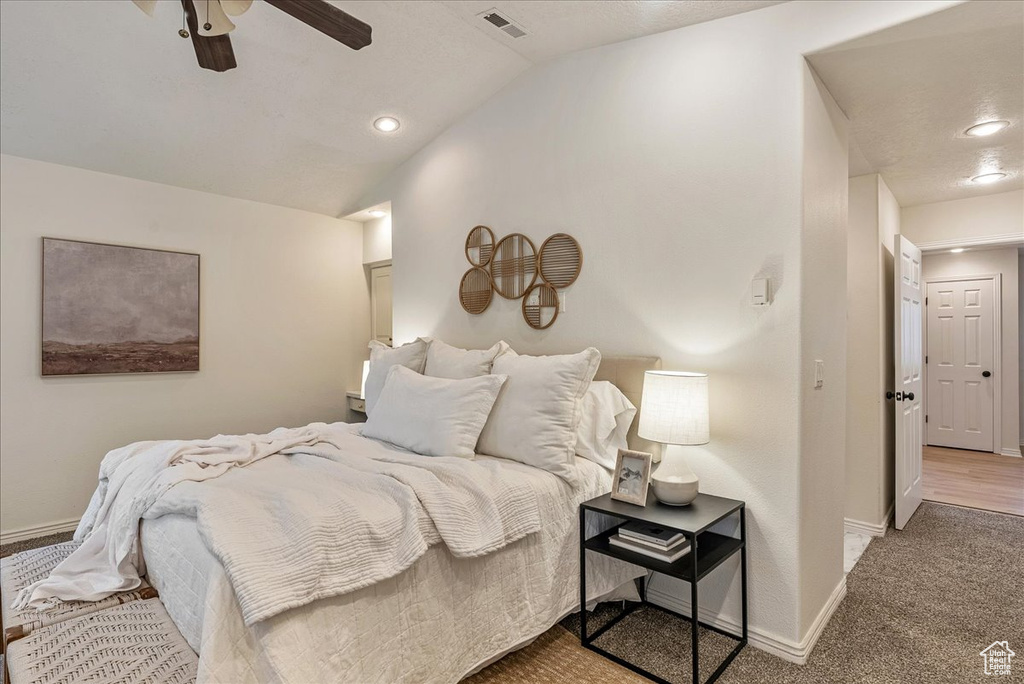Bedroom featuring visible vents, lofted ceiling, baseboards, a ceiling fan, and carpet
