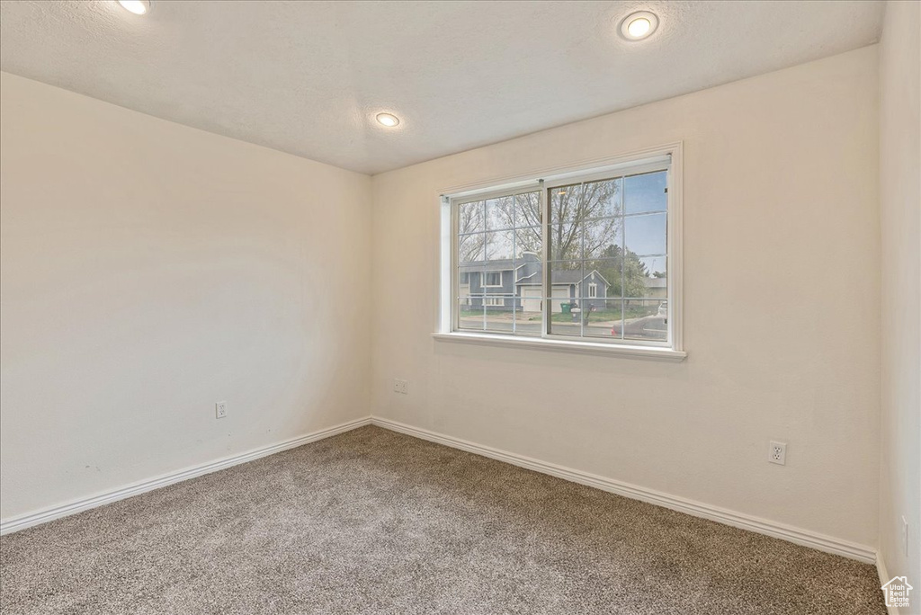 Spare room with baseboards, recessed lighting, and carpet