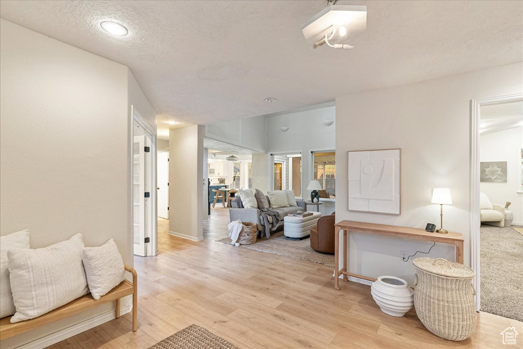 Interior space featuring recessed lighting, baseboards, light wood finished floors, and a textured ceiling
