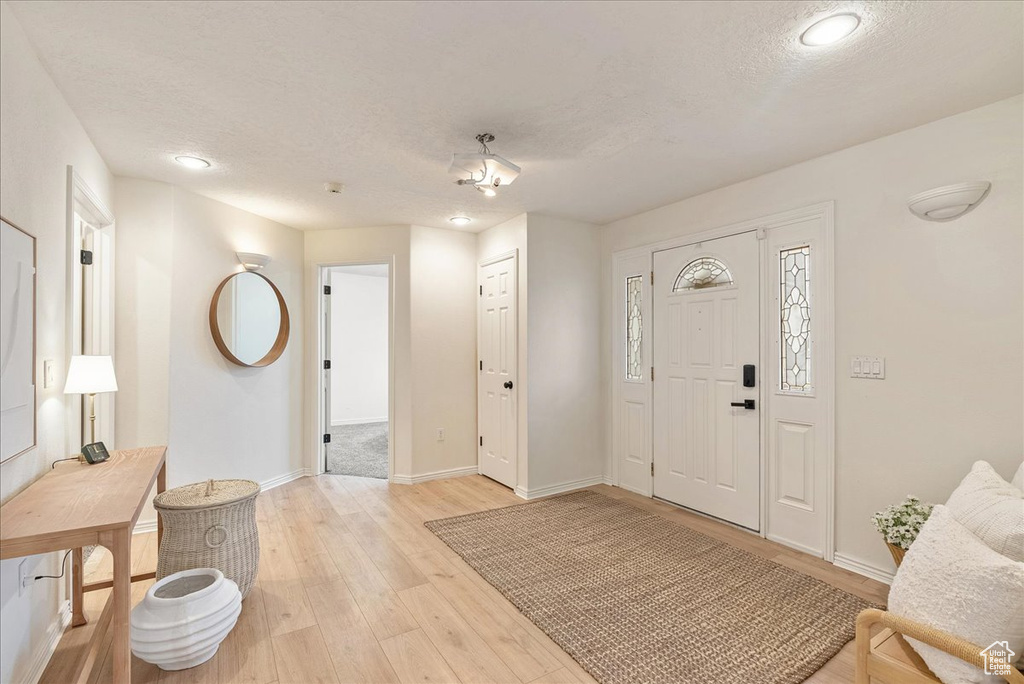 Entrance foyer with baseboards, a textured ceiling, light wood-style flooring, and recessed lighting