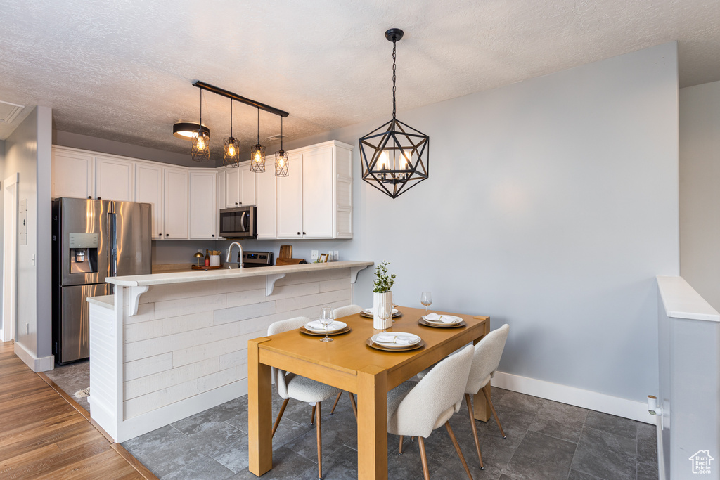 Dining area featuring baseboards and a textured ceiling
