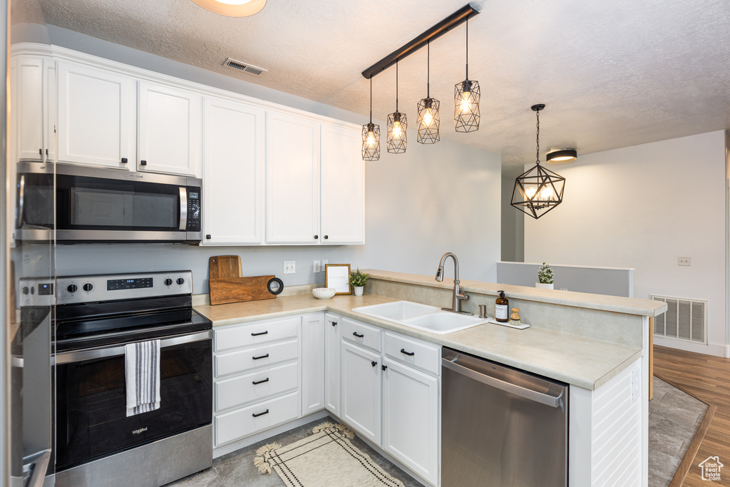 Kitchen featuring a sink, stainless steel appliances, a peninsula, and visible vents