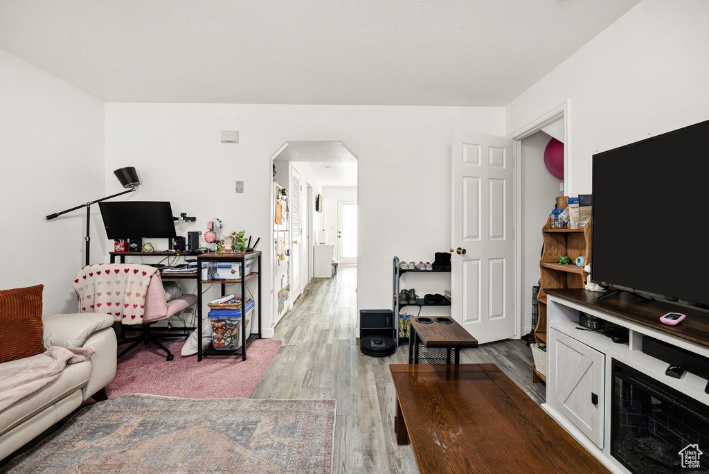 Living area featuring arched walkways and wood finished floors