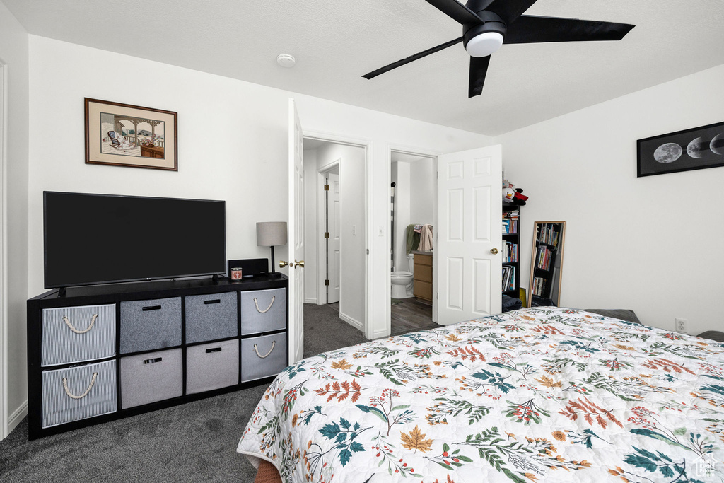 Bedroom with baseboards, ensuite bathroom, a ceiling fan, and dark carpet