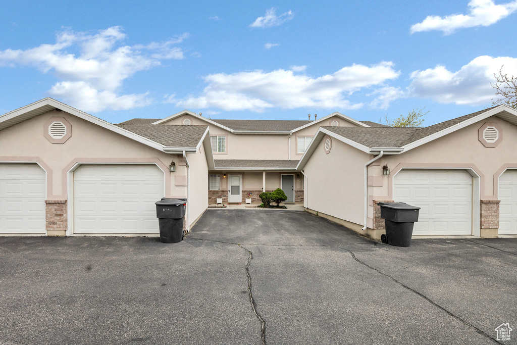 View of property featuring stucco siding and community garages