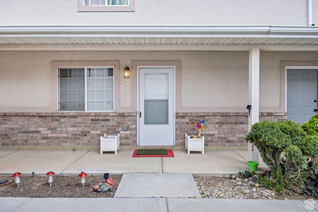 Property entrance featuring brick siding and stucco siding