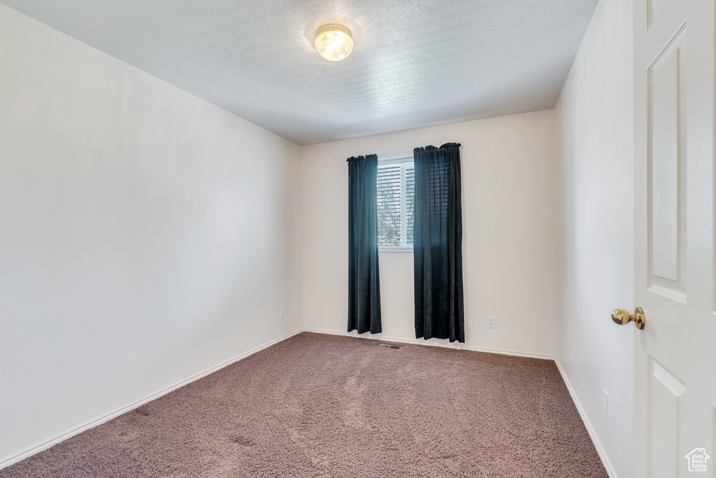 Spare room with carpet flooring, baseboards, and visible vents