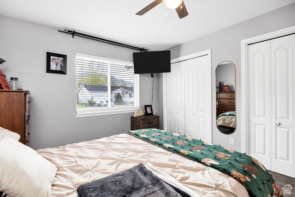 Bedroom featuring a ceiling fan and two closets