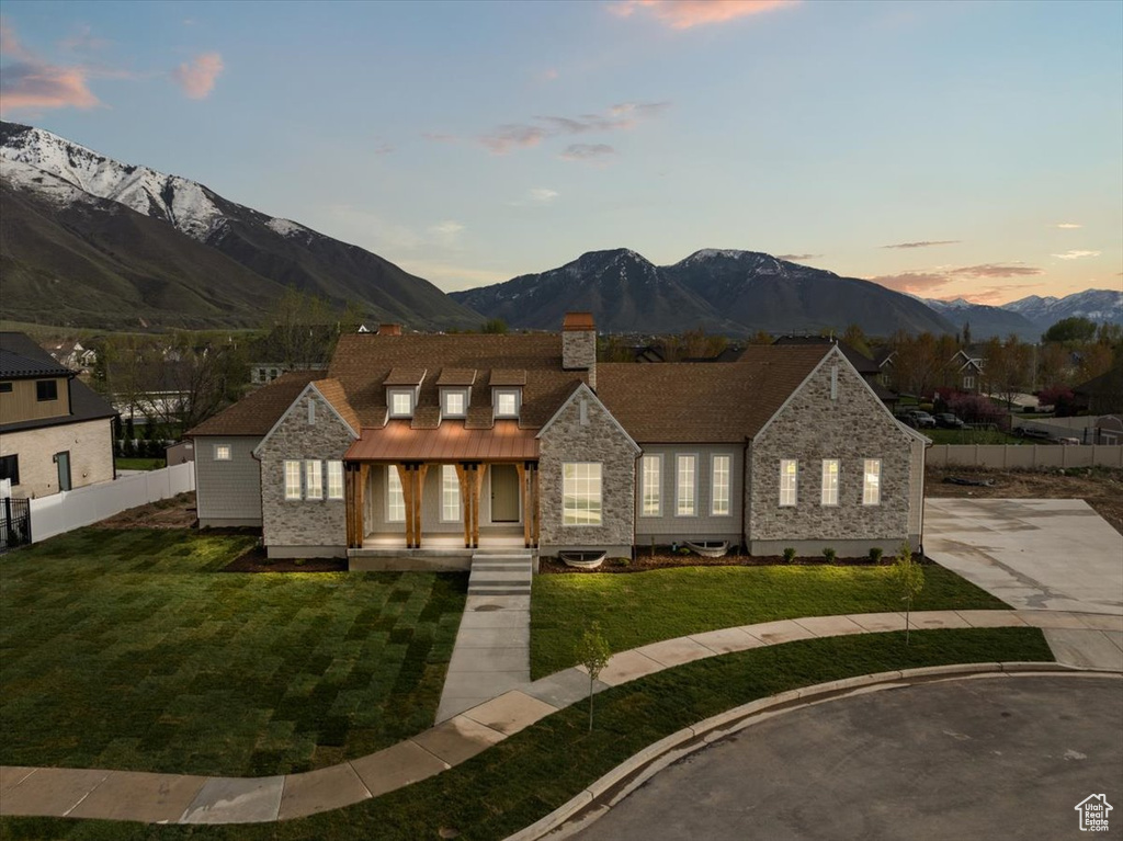 View of front of property with a mountain view, fence, covered porch, and a chimney