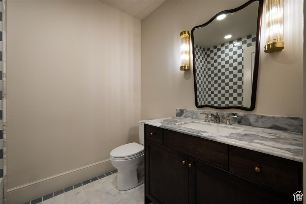 Bathroom with baseboards, toilet, and vanity