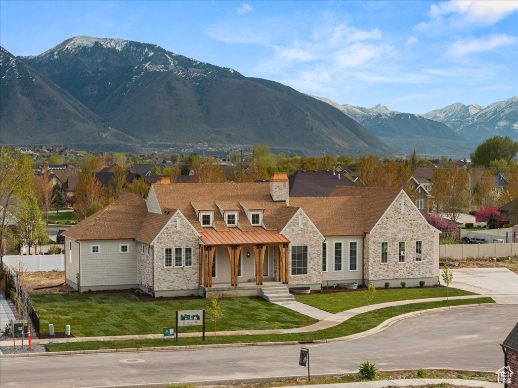 View of front of home featuring a porch, fence, a mountain view, and stone siding