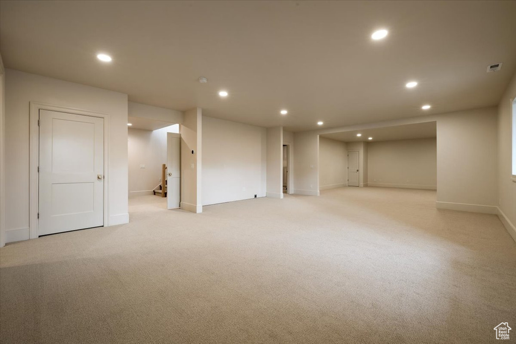 Basement featuring baseboards, recessed lighting, and light colored carpet