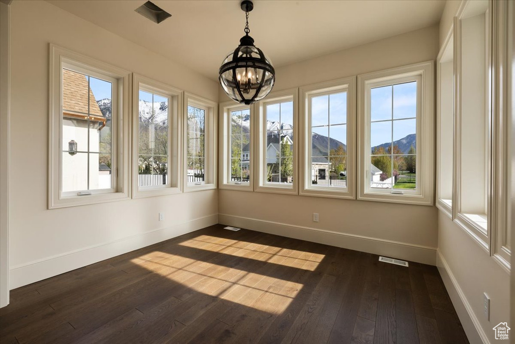 Unfurnished sunroom with a chandelier, a mountain view, and visible vents