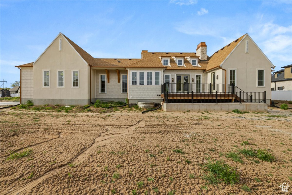 Rear view of property with a wooden deck, a shingled roof, and a chimney
