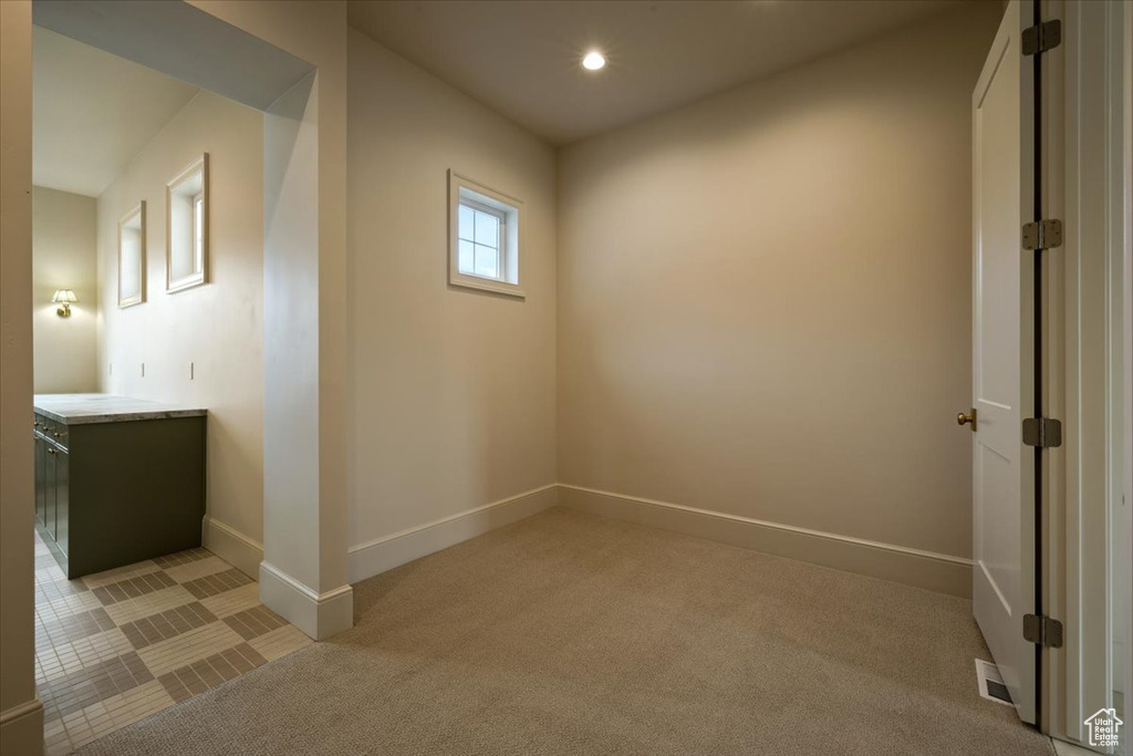 Spare room with baseboards, recessed lighting, and light colored carpet