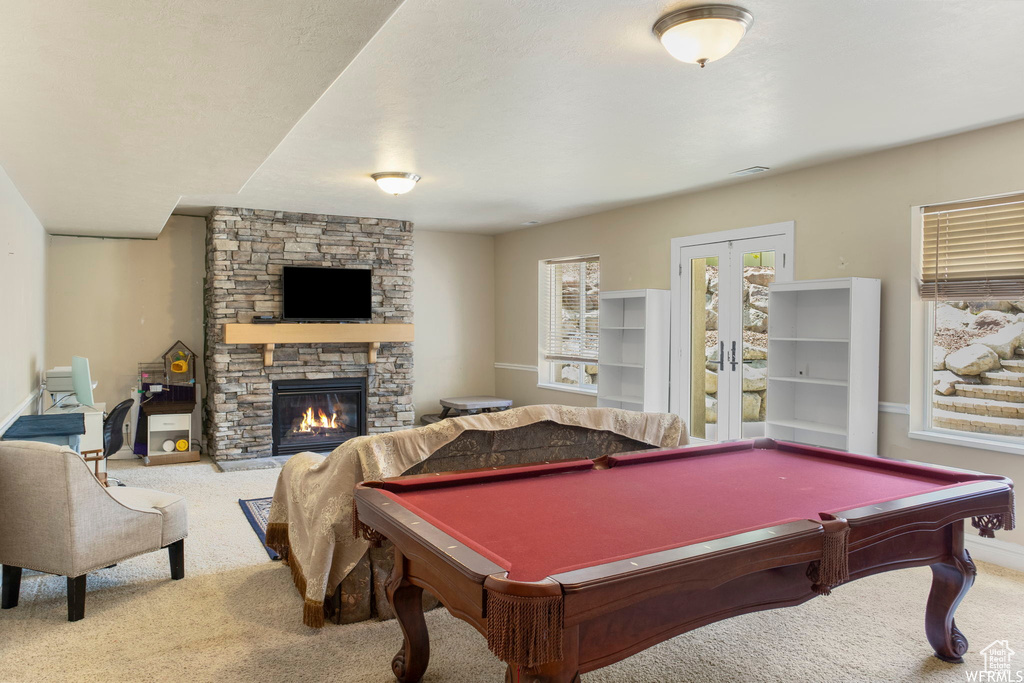 Rec room featuring a stone fireplace, billiards, carpet, and baseboards