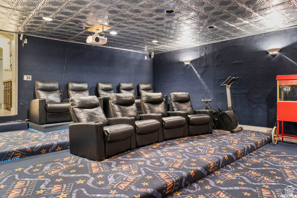 Carpeted cinema room featuring an ornate ceiling