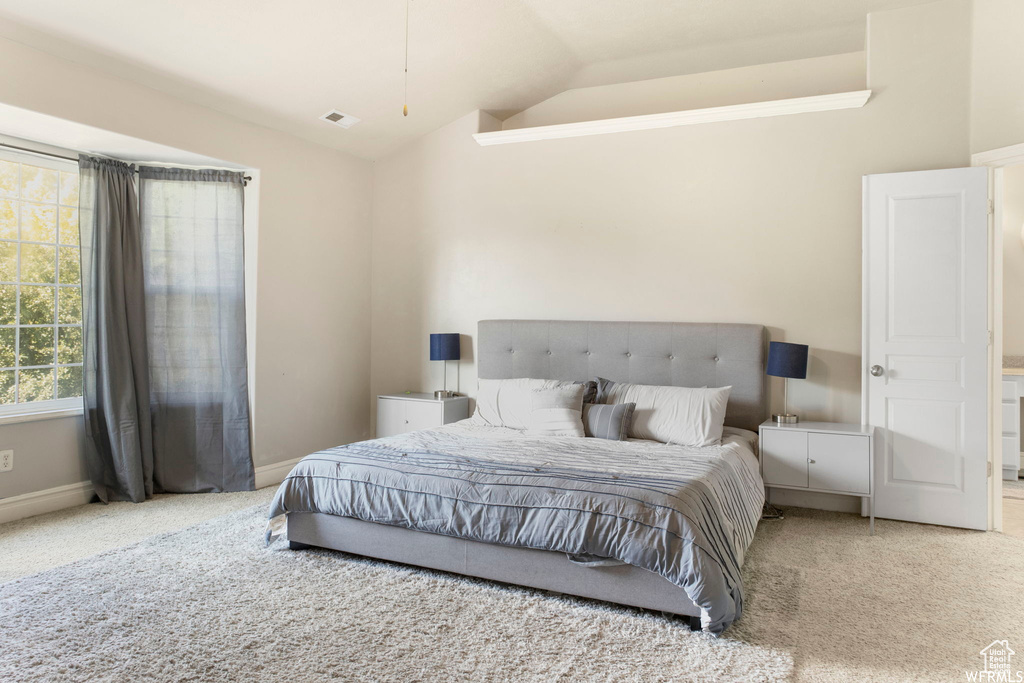 Bedroom with carpet floors, baseboards, vaulted ceiling, and visible vents
