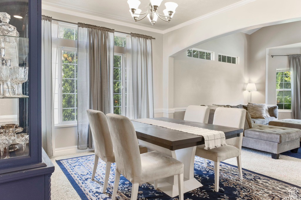 Dining area with an inviting chandelier, arched walkways, ornamental molding, and baseboards