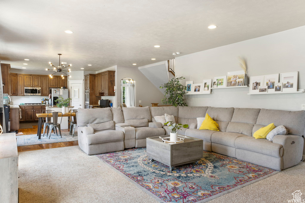 Living room with recessed lighting, a chandelier, and light carpet