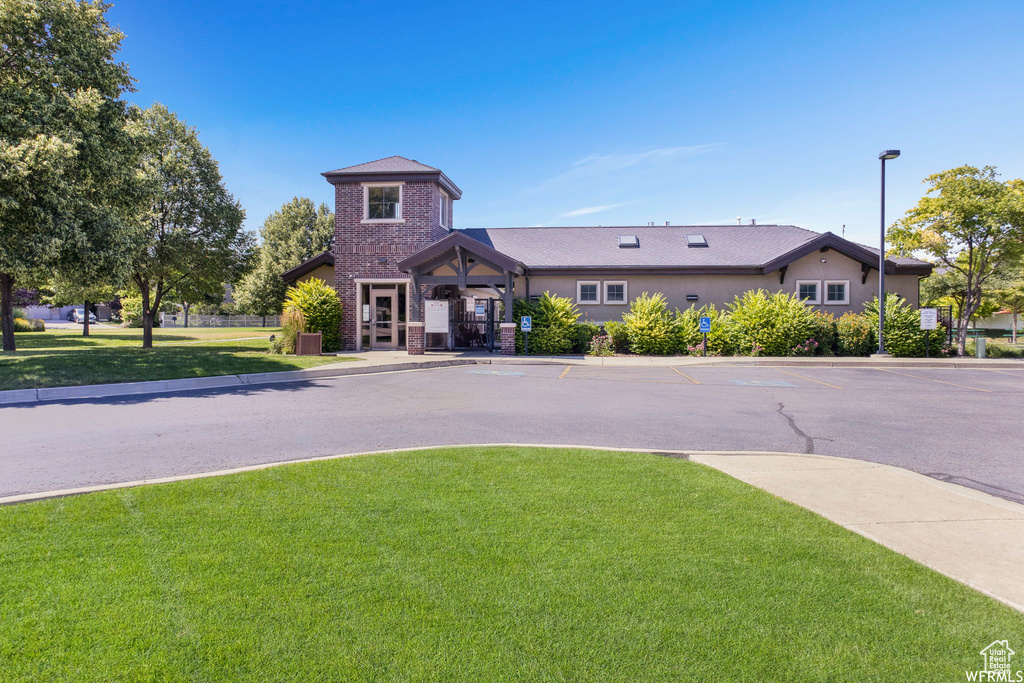 View of front of home featuring a front lawn and uncovered parking