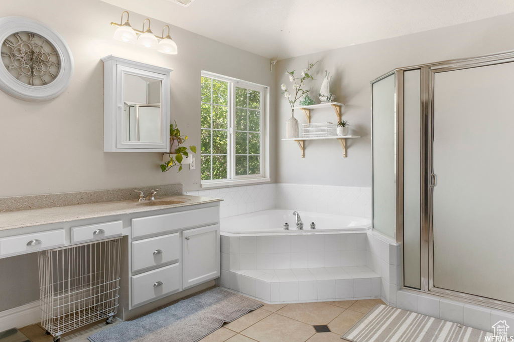 Bathroom featuring vanity, tile patterned floors, a garden tub, and a stall shower