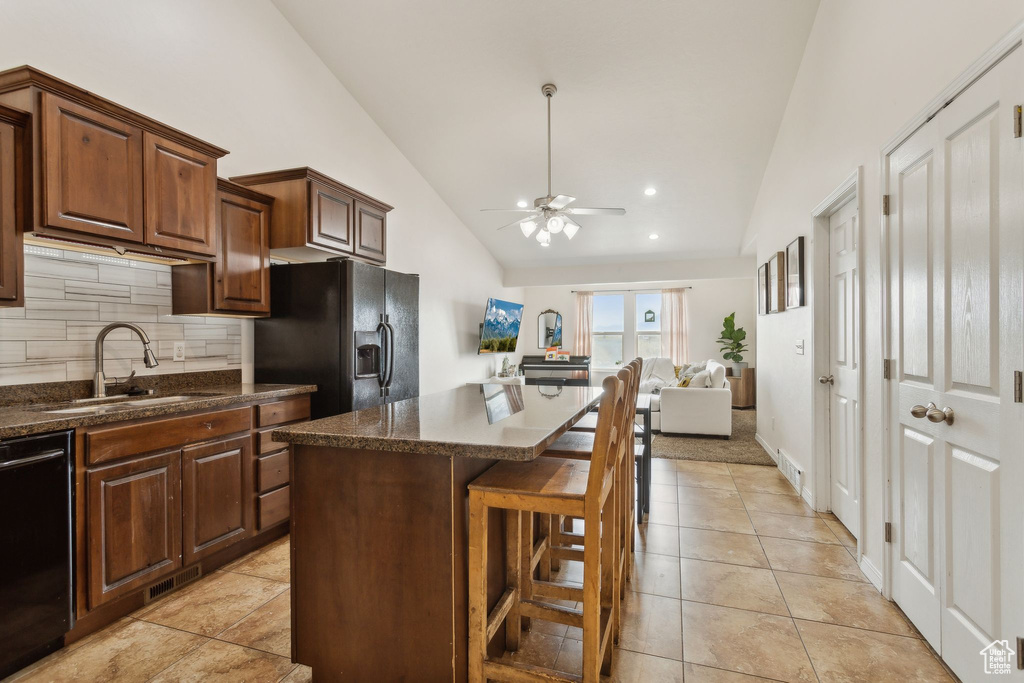 Kitchen featuring ceiling fan, backsplash, a sink, high vaulted ceiling, and black appliances