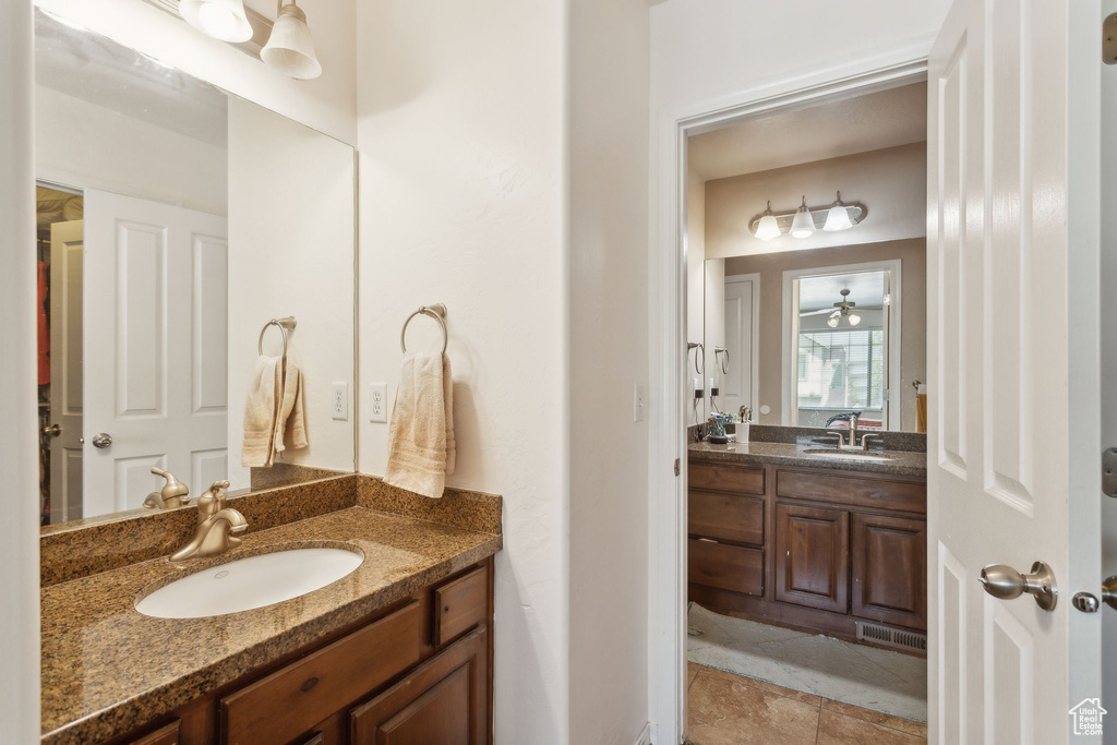 Bathroom featuring visible vents, a sink, two vanities, and tile patterned floors