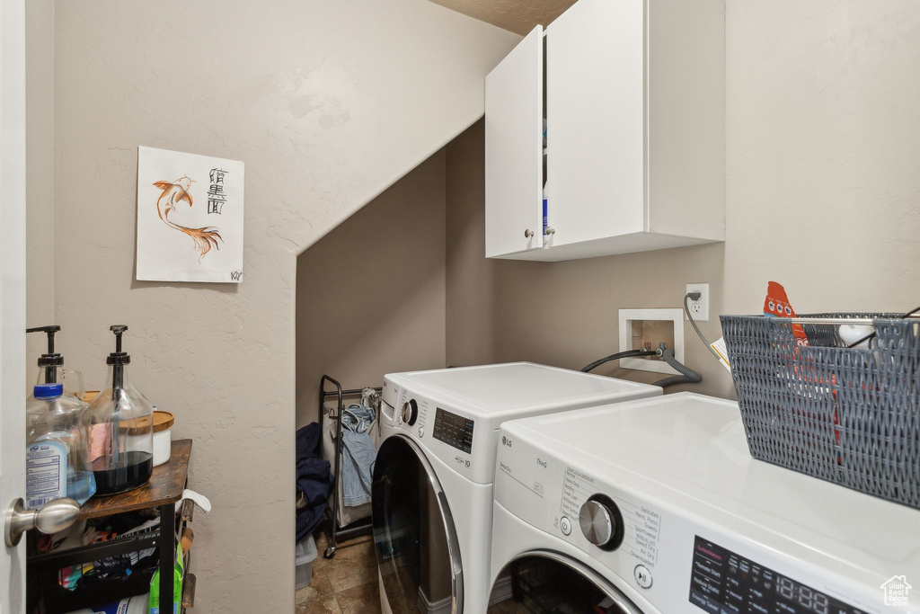 Laundry room with cabinet space and washer and clothes dryer