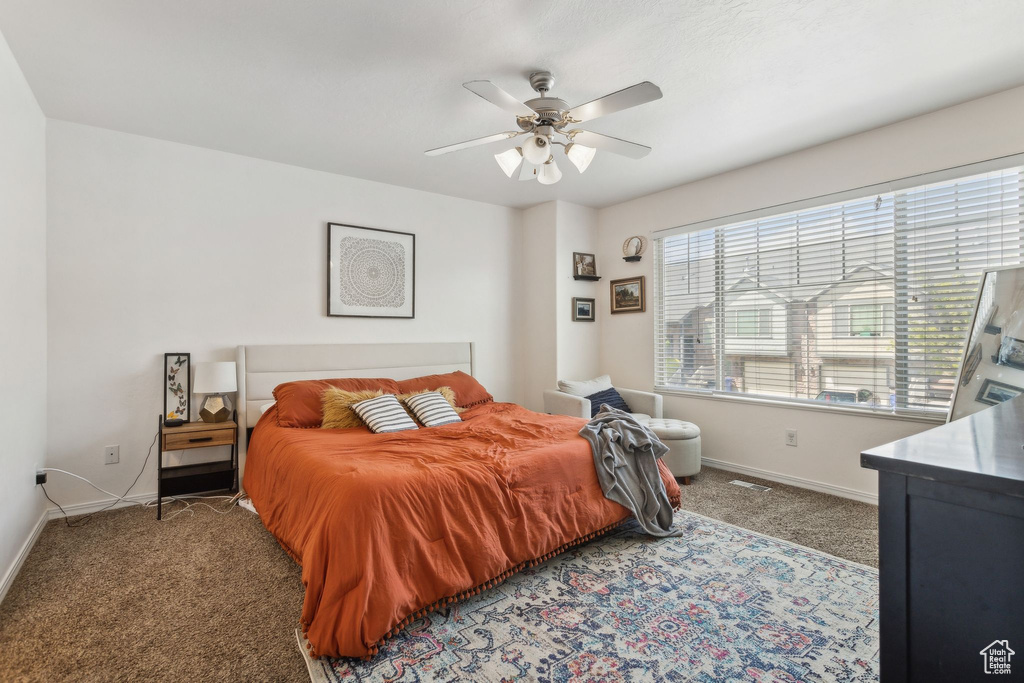 Carpeted bedroom featuring baseboards and ceiling fan