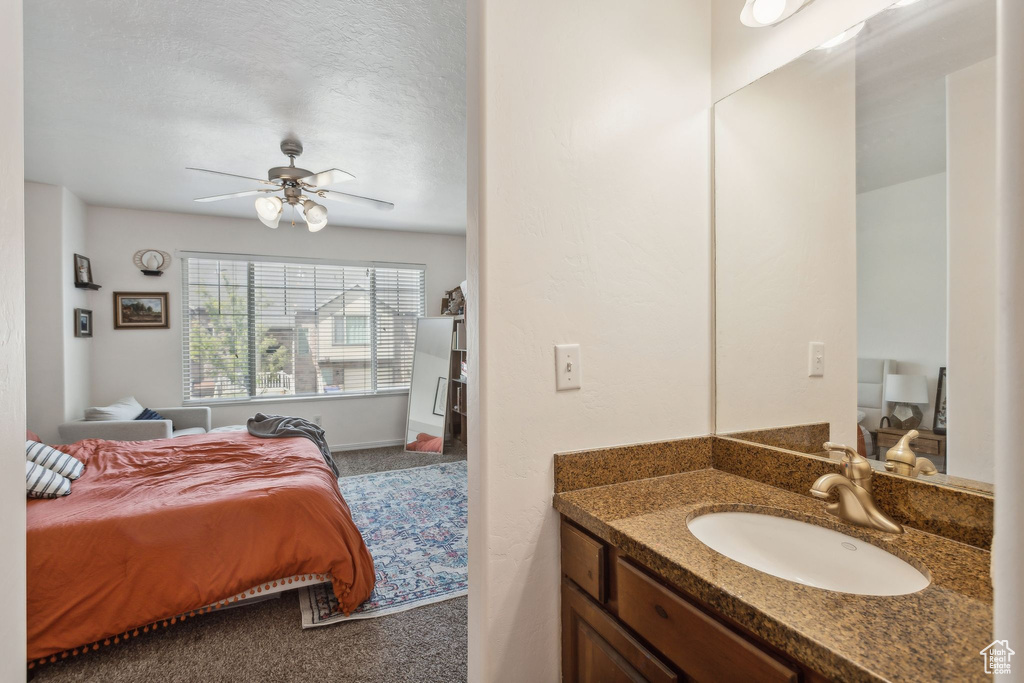 Bedroom featuring a sink, ceiling fan, and carpet flooring