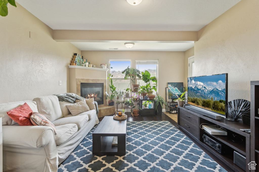 Living area with wood finished floors and a tile fireplace