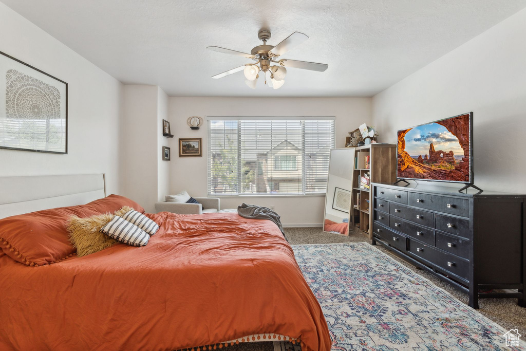 Bedroom with carpet floors, a ceiling fan, and baseboards