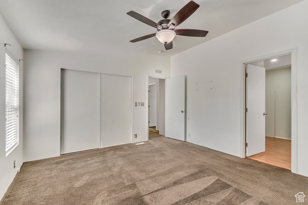 Unfurnished bedroom featuring a ceiling fan, carpet, a closet, and visible vents