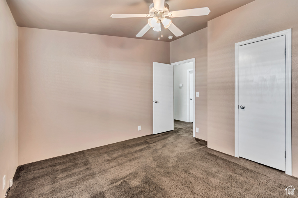 Unfurnished bedroom featuring ceiling fan and carpet flooring