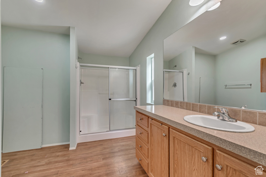 Bathroom featuring vanity, a shower stall, and wood finished floors