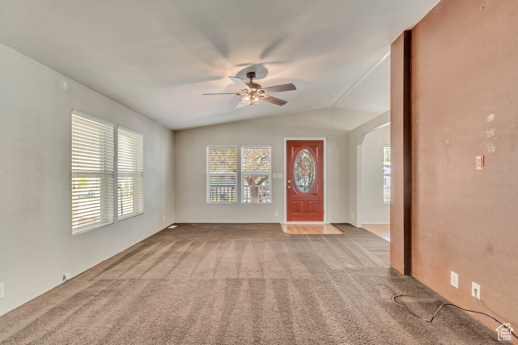 Carpeted entrance foyer featuring ceiling fan and lofted ceiling