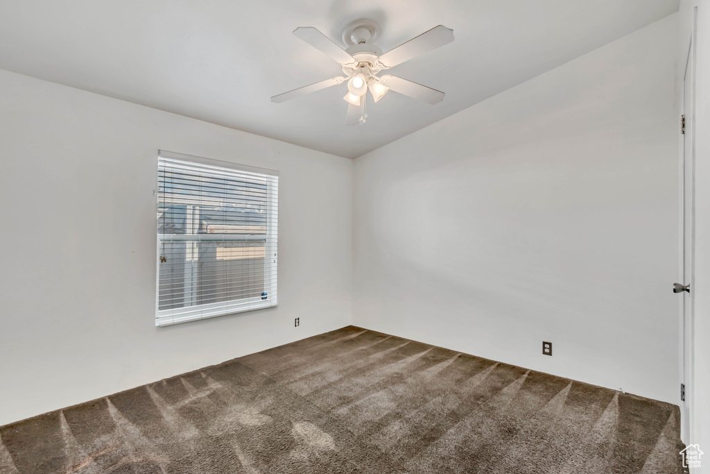 Spare room with dark carpet and ceiling fan