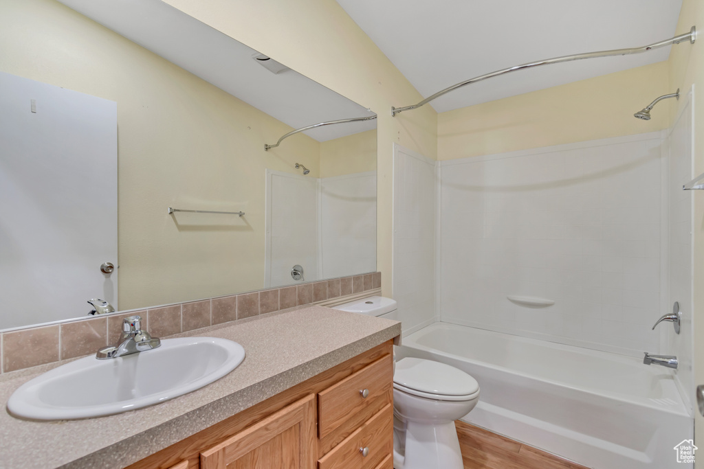 Bathroom with vanity, toilet, wood finished floors, and tub / shower combination